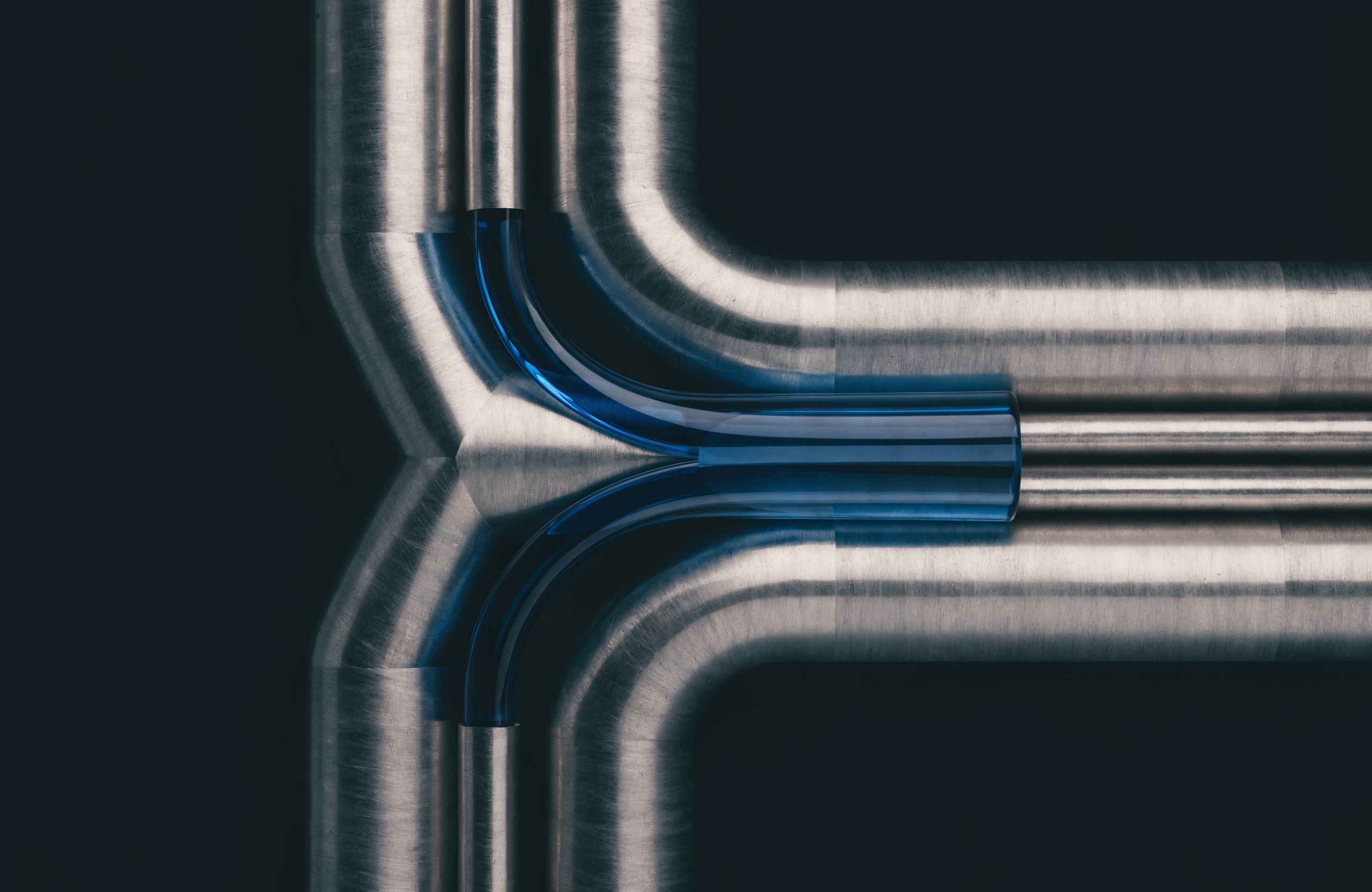 Precision metal pathways converging through a translucent blue junction